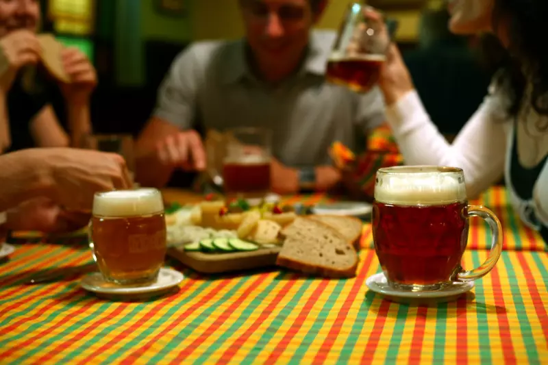 Společnost u stolu s půllitry světlého a polotmavého piva